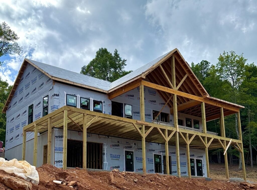 Broomtail Lane two-story construction progress showing framed timber porch posts and roof decking