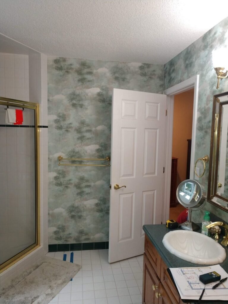 Original bathroom before renovation showing oak vanity and dated green countertop