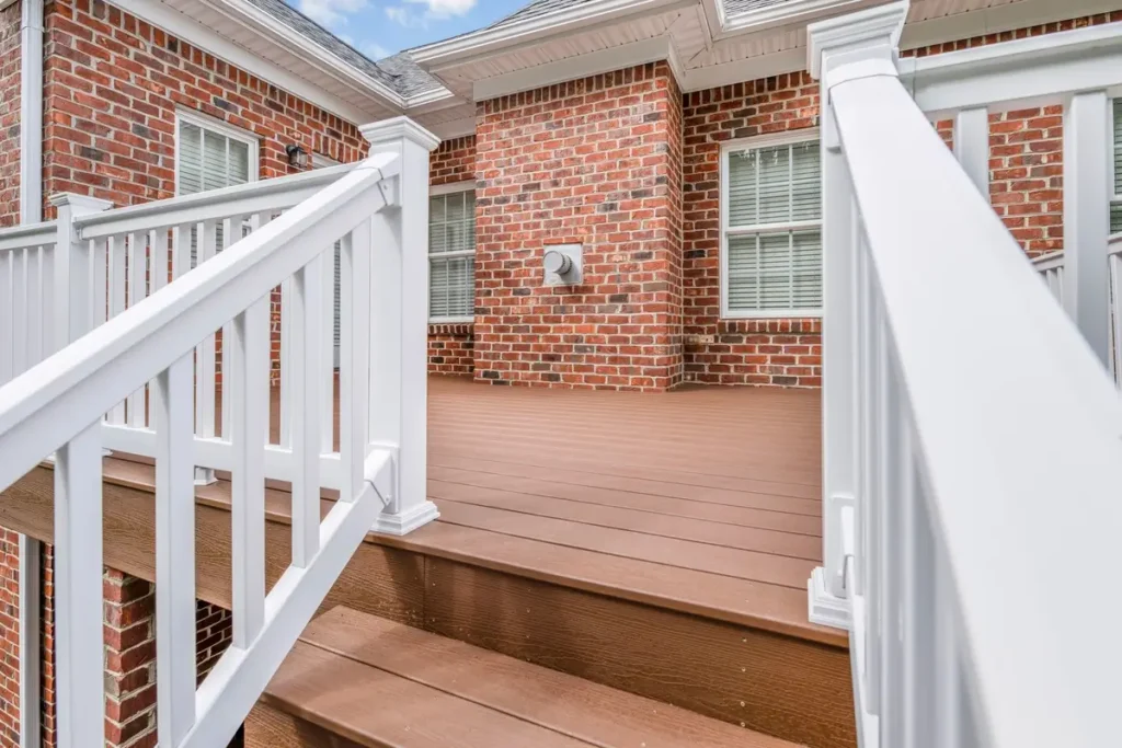 Turnstone Court deck landing where staircase meets brown composite decking against brick wall
