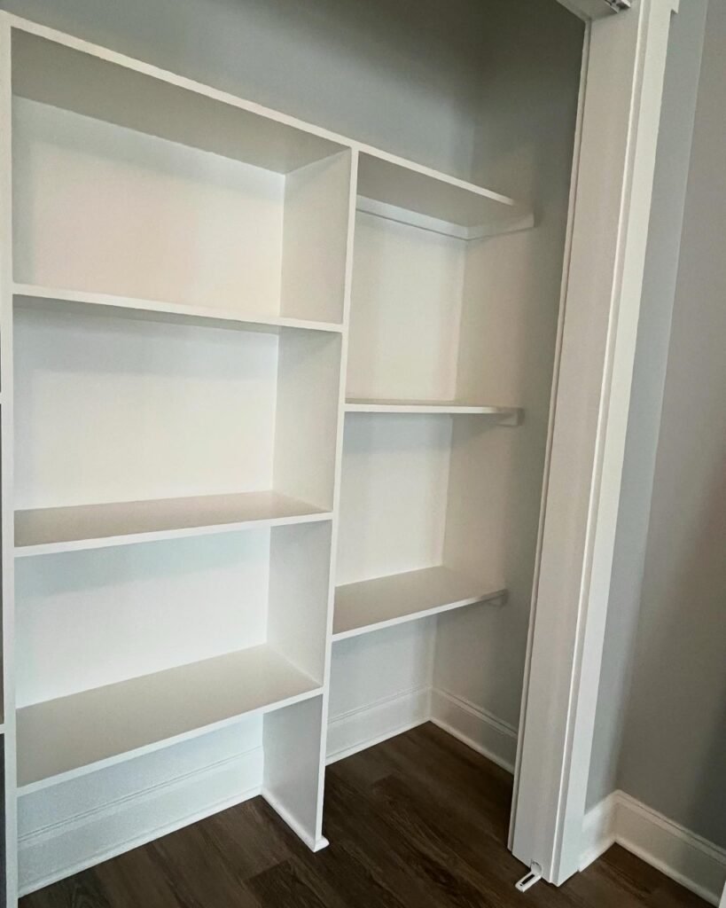 Custom built-in closet shelving with white cabinetry in the Lavender Farm Trail bedroom addition