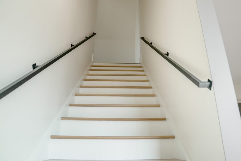 Open-riser staircase with white oak treads and black railings