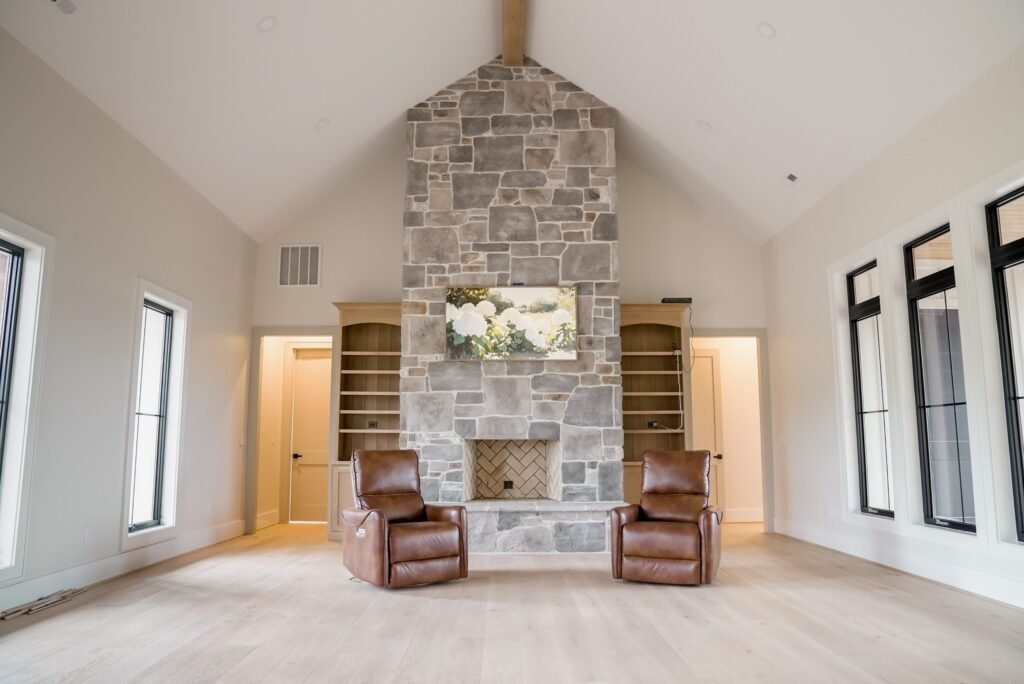 Vaulted great room with a floor-to-ceiling stone fireplace in the Jack Davis custom home