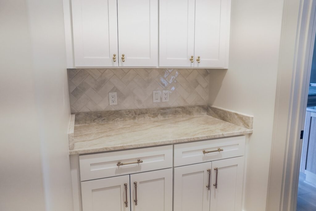 Custom kitchen in the Jack Davis home with marble counters, white oak cabinetry and a plaster range hood