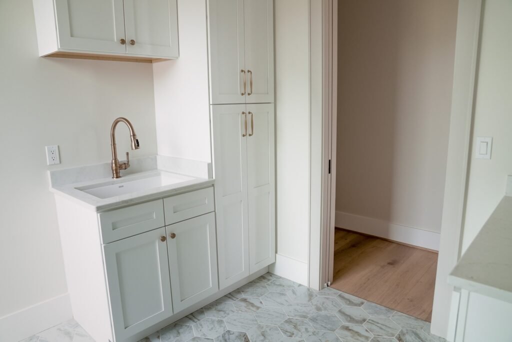 Custom kitchen in the Jack Davis home with marble counters, white oak cabinetry and a plaster range hood