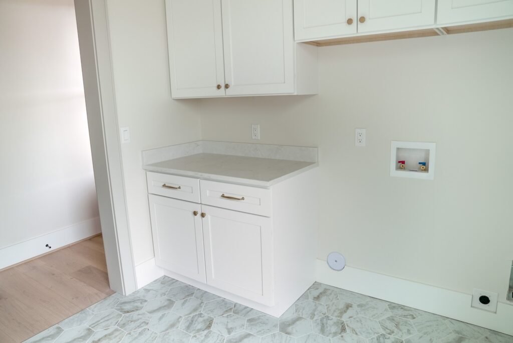 Custom kitchen in the Jack Davis home with marble counters, white oak cabinetry and a plaster range hood