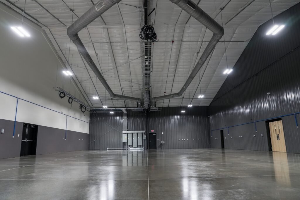 Main shop bay with exposed metal roof structure and epoxy flooring