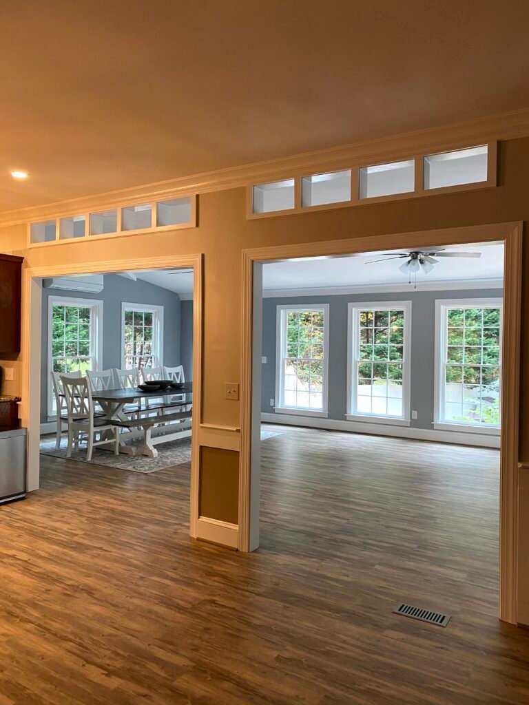 Two wide cased openings topped with transom windows lead from the hall into the dining area and window-lined living space