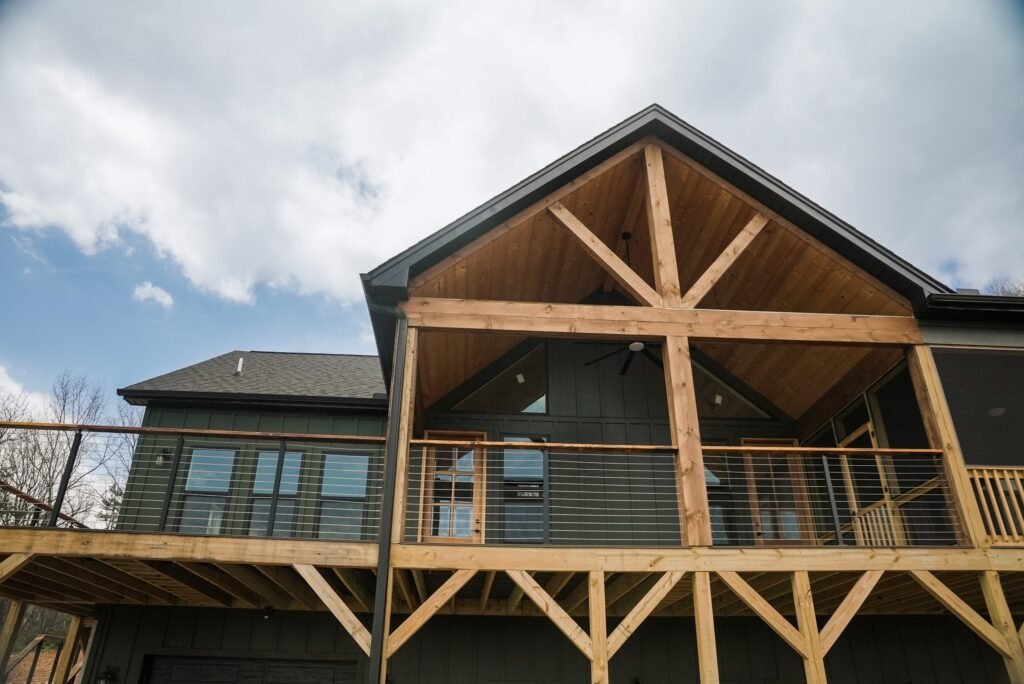 Rear timber-frame deck and covered porch overlooking the wooded lot